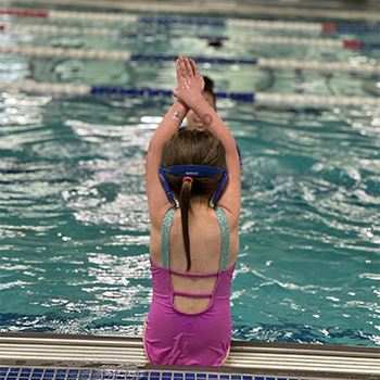 A young swimmer prepares to dive into a pool