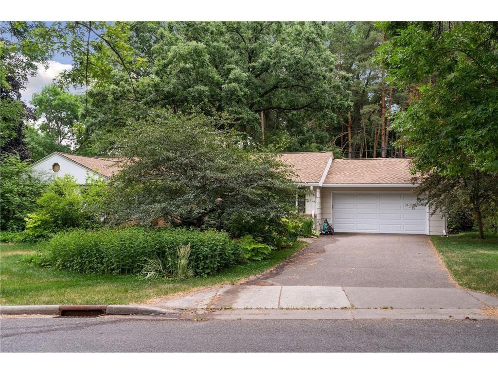 A photo of a home with overgrown foliage in the front yard